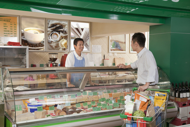 Sales Clerk assisting man at the Deli counter - Photo, Image