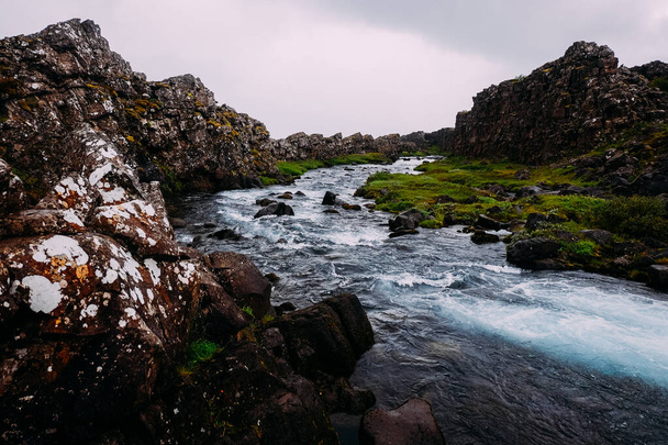 fiume di montagna tra scogliere e coste rocciose con acqua limpida nel parco nazionale estivo dell'Islanda
 - Foto, immagini