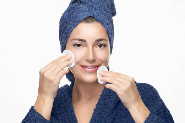Όμορφη υγιής νεαρή γυναίκα με φρέσκο καθαρό δέρμα χρησιμοποιώντας βαμβάκι μαξιλάρια για να καθαρίσετε το δέρμα του προσώπου. Προσωπική υγιεινή, καθημερινή περιποίηση προσώπου και δέρματος - Φωτογραφία, εικόνα