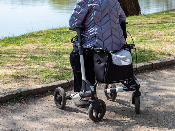 Vanha nainen kävelyä tukea puistossa
 - Valokuva, kuva