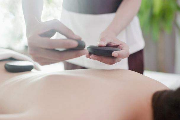 Mulher recebendo massagem de pedra quente
 - Foto, Imagem