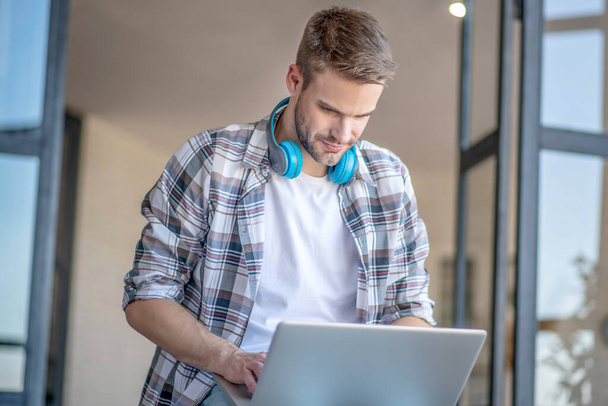 Young man in a checkered shirt sending an email - Foto, Imagem