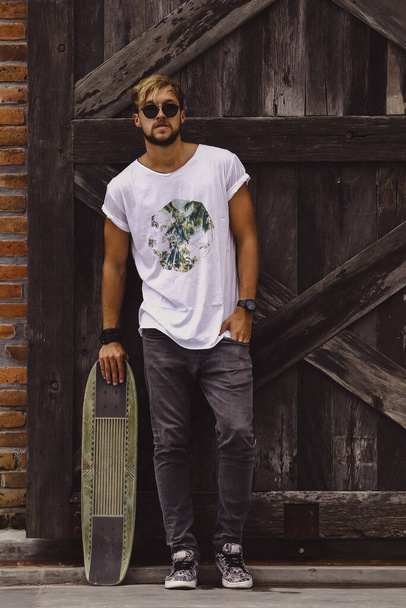 Hipster style guy. young skater man with a skateboard in casual  - Фото, зображення