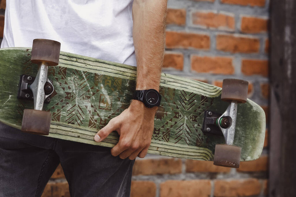 skateboard in the hand of a man. Close-up. hand holds skateboard - Foto, imagen
