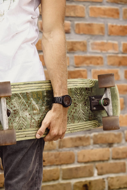 skateboard in the hand of a man. Close-up. hand holds skateboard - Zdjęcie, obraz