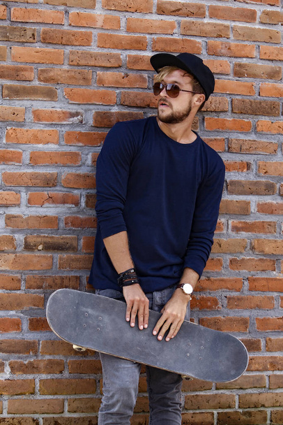 young man with a skateboard. casual wear. - Foto, Imagen