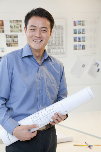 Liikemies seisoo jumissa papereita toimistossa
 - Valokuva, kuva