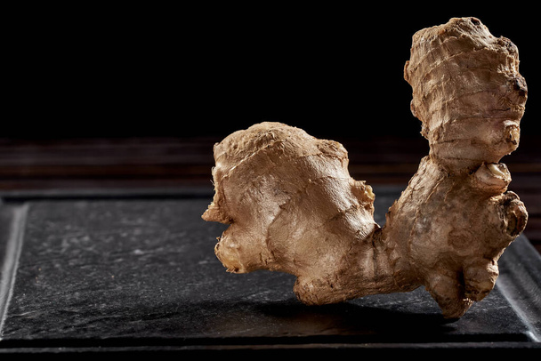 Ginger root on a black background. side view. volume ripe product. macro photo. Against viruses and diseases. studio photo - Photo, Image