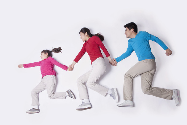 Familia cogida de la mano e imitando correr
 - Foto, Imagen