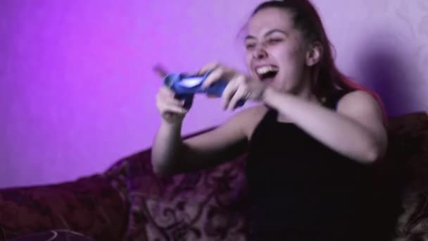 ein Mädchen ohne Make-up zu Hause freut sich über den Gewinn eines Videospiels, ein Spieler tanzt auf der Couch und freut sich über den Gewinn - Filmmaterial, Video