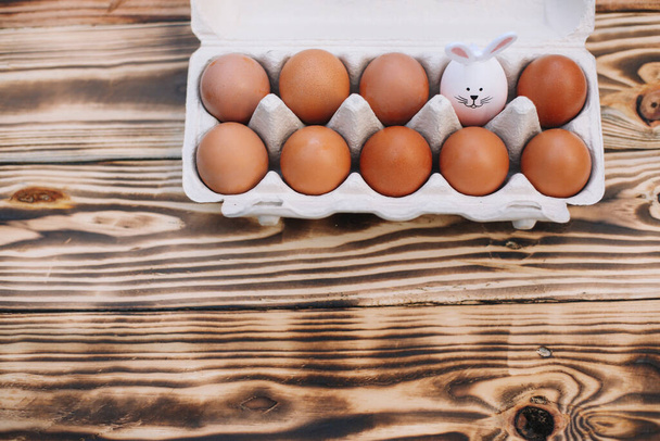 Вид сверху 9 пасхальных яиц и 1 яйцо с ушами кролика. Пасхальный кролик. Место для текста
. - Фото, изображение
