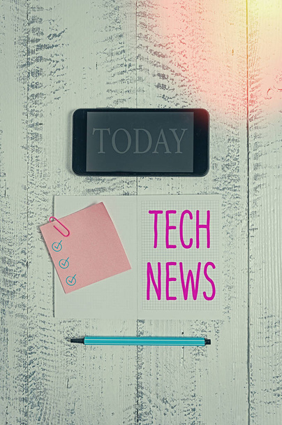 Conceptual hand writing showing Tech News. Business photo text newly received or noteworthy information about technology Squared notebook marker smartphone sticky note wooden background. - Photo, Image