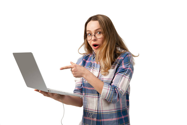 Emotional caucasian woman using laptop on white studio background, technologies. Shocked pointing - Foto, imagen