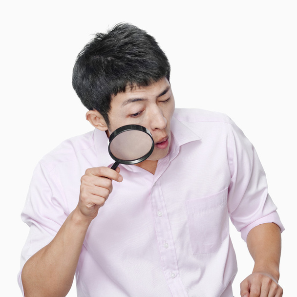 Man looking through magnifying glass - Photo, Image