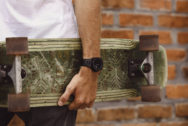 skateboard in the hand of a man. Close-up. hand holds skateboard - 写真・画像