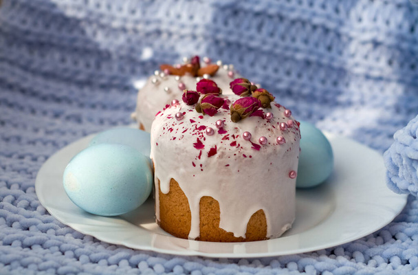 Velikonoční chléb, dort a vejce s dekorem květin, korálků a ořechů. Modrý pletený kostkovaný. Koncept velikonočních svátků a dekorace. - Fotografie, Obrázek
