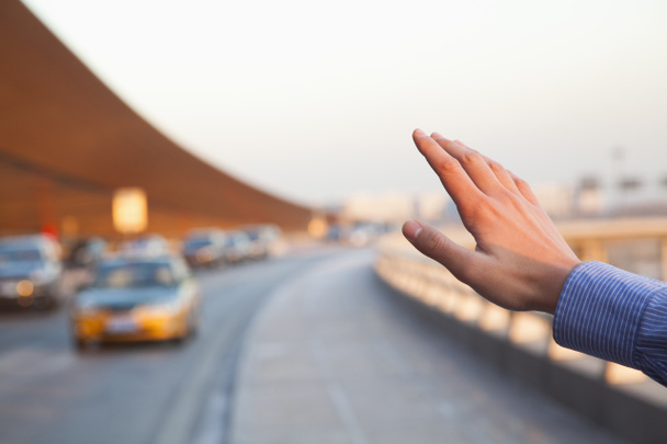 Hand of traveler hailing a taxi - Photo, Image
