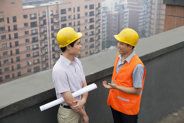 Architect And Construction Worker Talking On Rooftop - Fotoğraf, Görsel