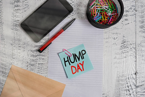 Handwriting text Hump Day. Concept meaning climbing a proverbial hill to get through a tough week Wednesday Smartphone paper sheet clips holder pen envelope note wooden background. - Photo, Image