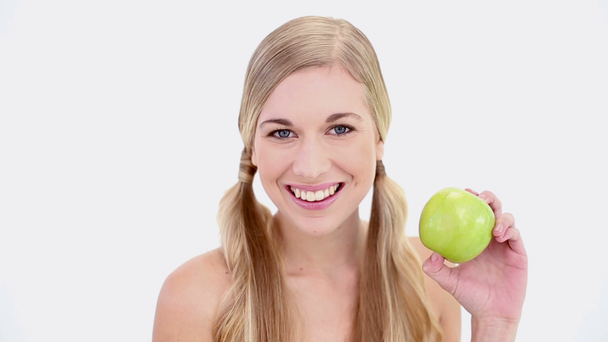 Happy nude blonde holding green apple - Filmati, video