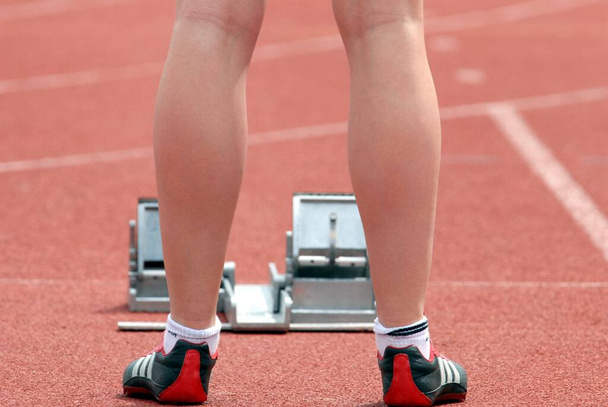 Frau am Start eines Leichtathletik-Rennens vor den Startlöchern - Foto, Bild