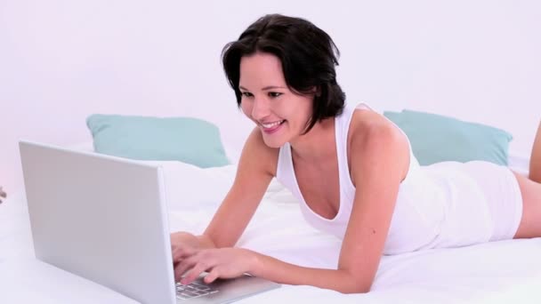 Amused calm woman typing on her laptop - Кадри, відео