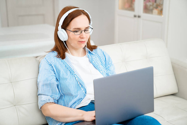 woman works at the computer with headphones  - Fotoğraf, Görsel