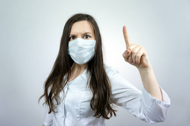 Covid19, coronavirus, woman doctor point finger with idea, wear medical mask to prevent catching virus, white coat. - 写真・画像