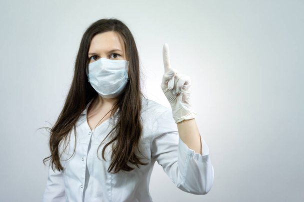 Covid19, coronavirus, girl doctor point finger with idea, wear medical mask to prevent catching virus, white coat. - Fotografie, Obrázek