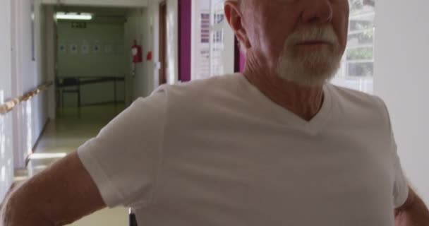 Закрити старшого кавказького чоловіка з білою бородою, використовуючи інвалідне крісло в коридорі на пенсійному будинку, ізолюючи і соціальну дистанцію під час коронавірусу covid19 пандемії. У повільному русі - Кадри, відео