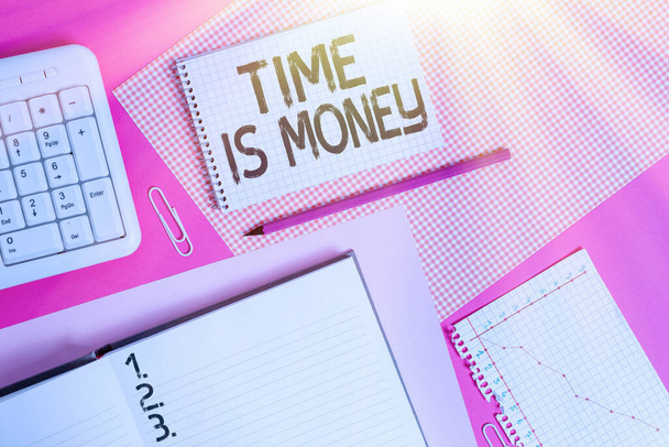Psaní textu Time Is Money. Obchodní koncept pro dělat věci tak rychle, jak je možné a ne ztrácet čas psaní zařízení a počítačů umístěných nad barevným prostým stolem. - Fotografie, Obrázek