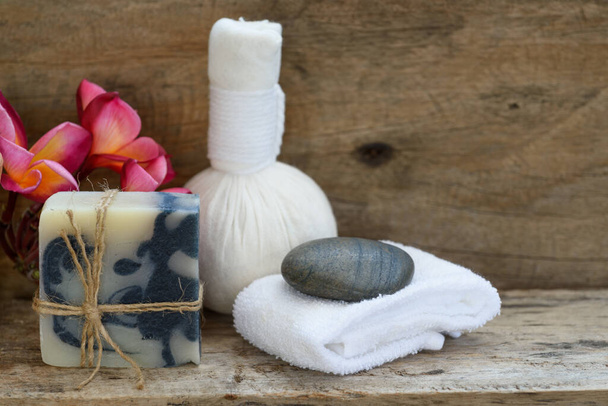Bola de massagem de ervas e produtos de aromaterapia de spa de sabão índigo em fundo de madeira
 - Foto, Imagem