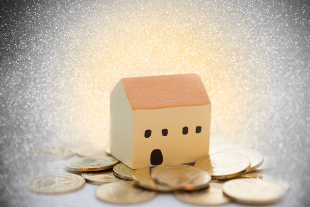 House and  golden coins  with bokeh blurred background,properties concept - Photo, Image