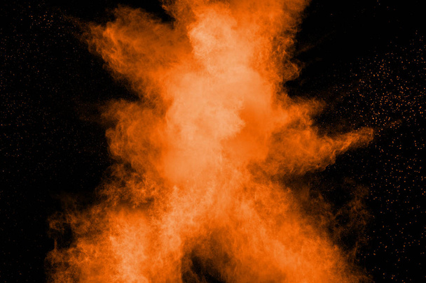 Abstraktní výbuch oranžového prachu na černém pozadí. Zastavit pohyb oranžového prášku stříkání. - Fotografie, Obrázek