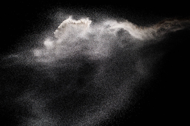 Esplosione di polvere bianca. Movimento di congelamento di particelle di polvere bianca su sfondo nero
. - Foto, immagini