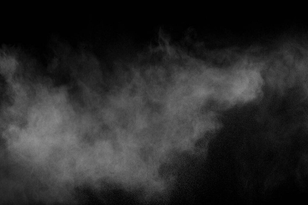 Siyah zemine karşı soyut beyaz toz patlaması. Havada beyaz toz esiyor.. - Fotoğraf, Görsel