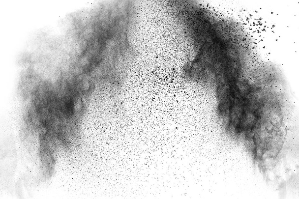 Fekete részecskék fröcskölnek fehér háttéren. Fekete por felrobbant.. - Fotó, kép