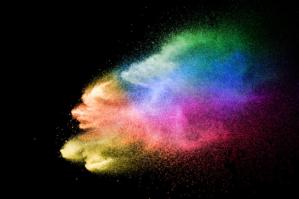 Abstract multicolored powder explosion on black background. Color dust particle splattered on background. - Photo, Image