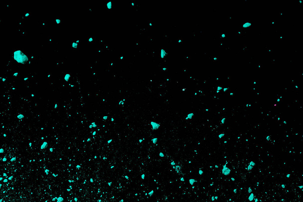 Uno schizzo di polvere di pigmento verde blu colorato su sfondo nero
. - Foto, immagini