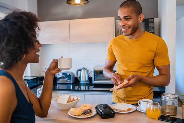 Portrait of happy young couple having breakfast together at home. Relationship and lifestyle concept. - Foto, imagen