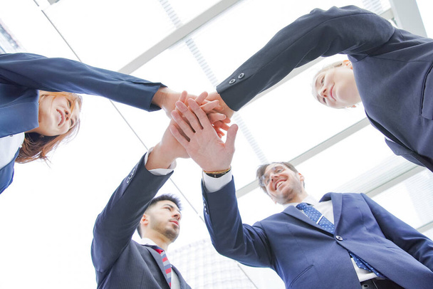 Un equipo de empresarios se superpone a las manos de los miembros para fortalecer la unidad
 - Foto, Imagen