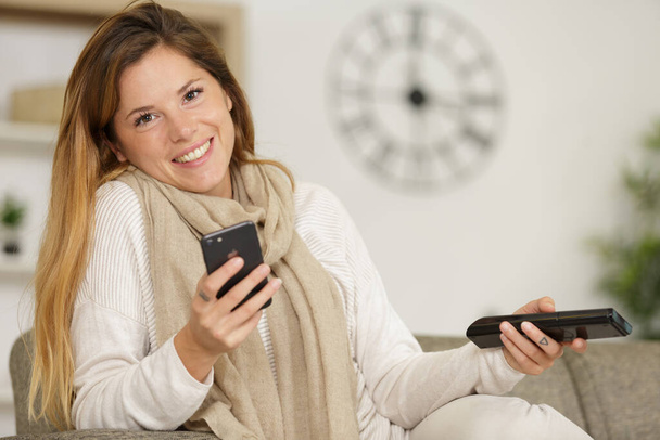 happy woman using mobile phone on sofa - Zdjęcie, obraz