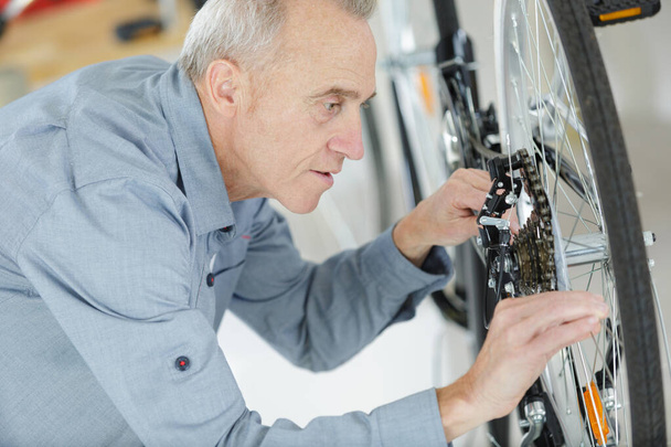 older man repairing a bicycle - Photo, Image