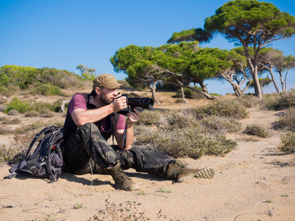Hombre fotógrafo en savanna tomando una foto de una vida salvaje de un animal
. - Foto, Imagen