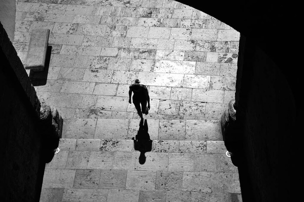 Людина, яка йде проти світла в сонячний літній день в місті Валенсія. Повітряний вид і зроблений чорно-білим. - Фото, зображення