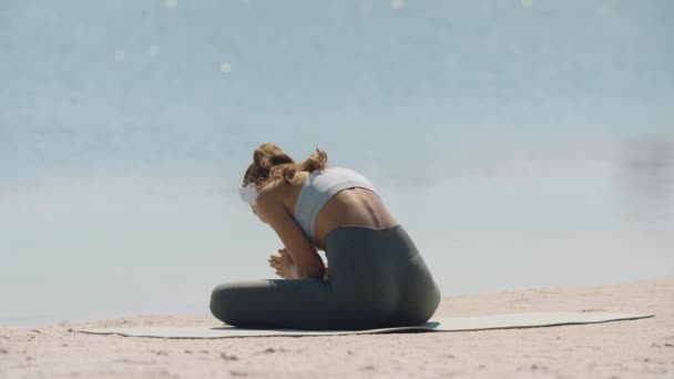Γυναίκα Διαλογισμό σε Yoga Pose στην παραλία - Πλάνα, βίντεο