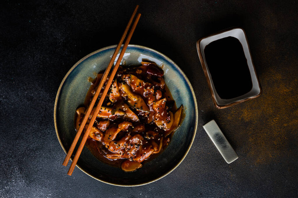 Παραδοσιακό κινέζικο φαγητό με γλυκόξινο χοιρινό σερβίρεται σε τσιμεντένιο φόντο με αντίγραφο χώρο - Φωτογραφία, εικόνα