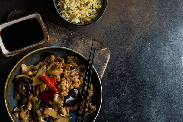 Comida tradicional china pollo con setas y verduras servidas sobre fondo de hormigón con espacio para copiar
 - Foto, Imagen