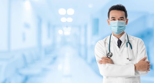Lekarz w szpitalu w masce medycznej w celu ochrony przed chorobą koronawirusową 2019 lub wybuchem COVID-19 na świecie. - Zdjęcie, obraz