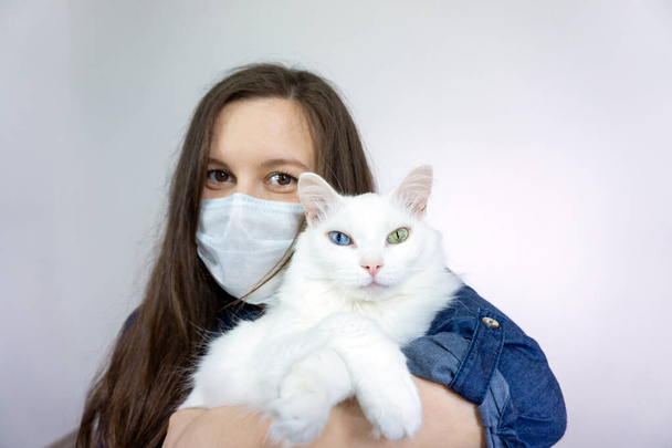 woman with cat, wearing a health mask, isolated in the background, flu epidemic, dust Allergy, virus protection. - Zdjęcie, obraz